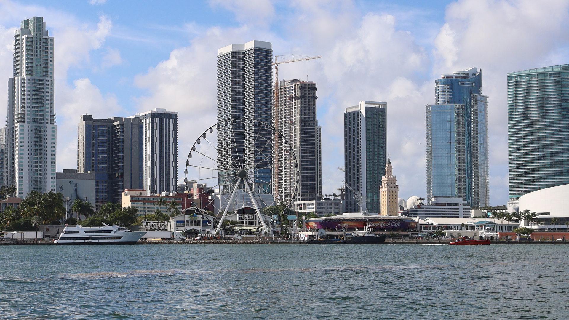 The ferris wheel stands against the towering skyscrapers in Miami.